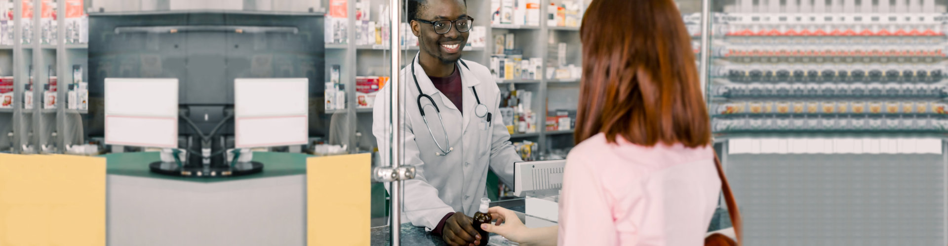 Smiling male pharmacist giving medicine